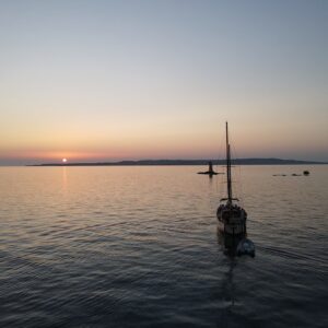 tramonto in barca a vela faro di Mangiabarche - Calasetta - Nido dei Passeri